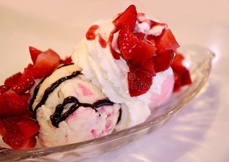 Strawberry cheesecake ice cream sundae topped with fresh berries and whipped cream