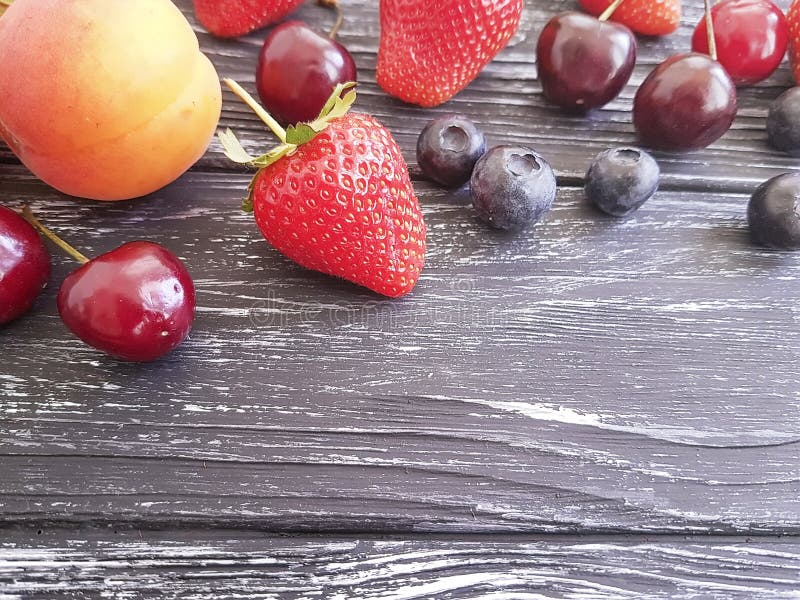 Strawberry, cherry, blueberry, delicious apricot on a wooden background royalty free stock image Strawberry, cherry, blueberry, delicious apricot on a wooden background royalty free stock image