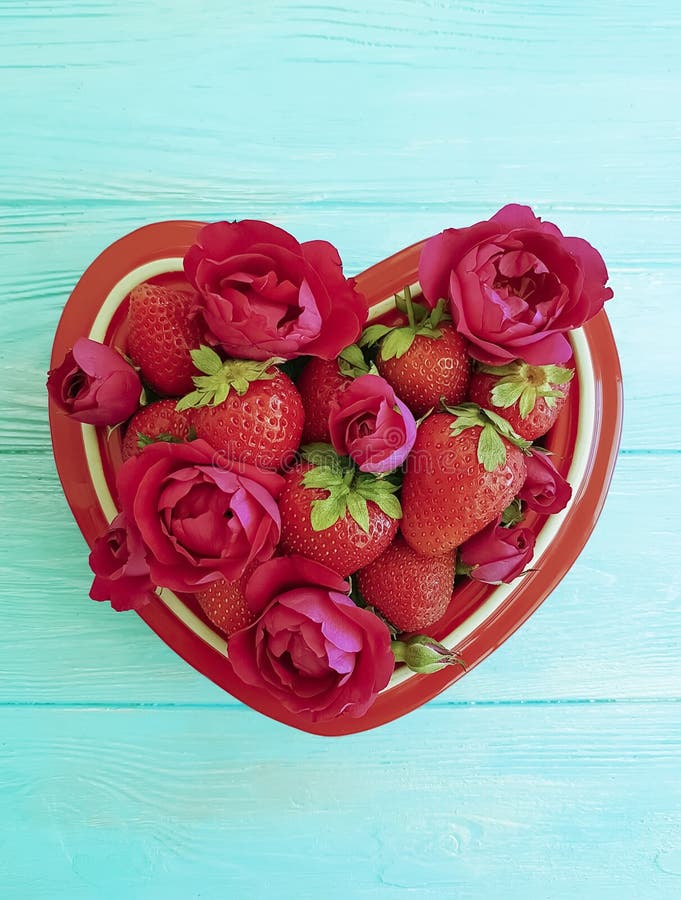 Strawberry dish heart, flower rose dessert on colored wooden background