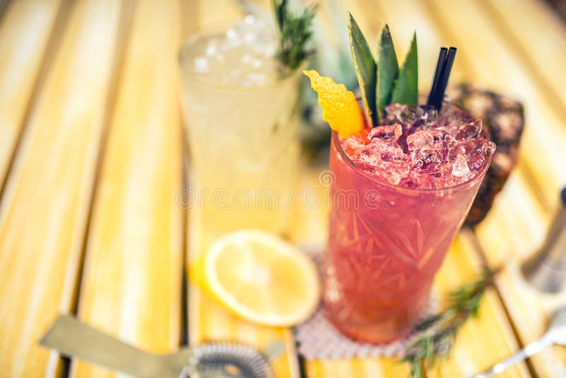 Strawberry pineapple alcoholic beverage, served cold with ice at bar. Cocktail drinks with lime, pineapple and alcohol as refr