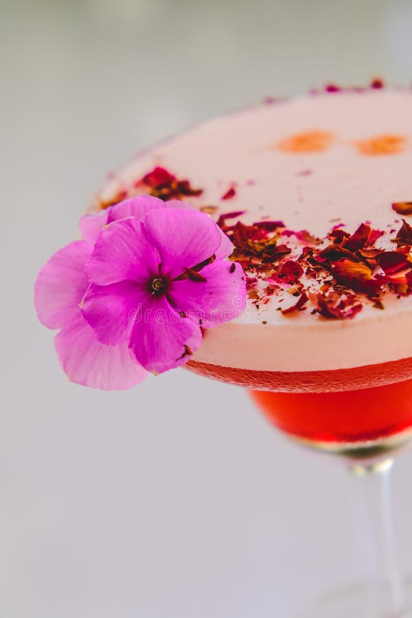 Strawberry rose cocktail with purple flower. Delicious strawberry rose cocktail with purple flower on top. Decorated with roses stock photos Strawberry rose cocktail with purple flower. Delicious strawberry rose cocktail with purple flower on top. Decorated with roses stock photos
