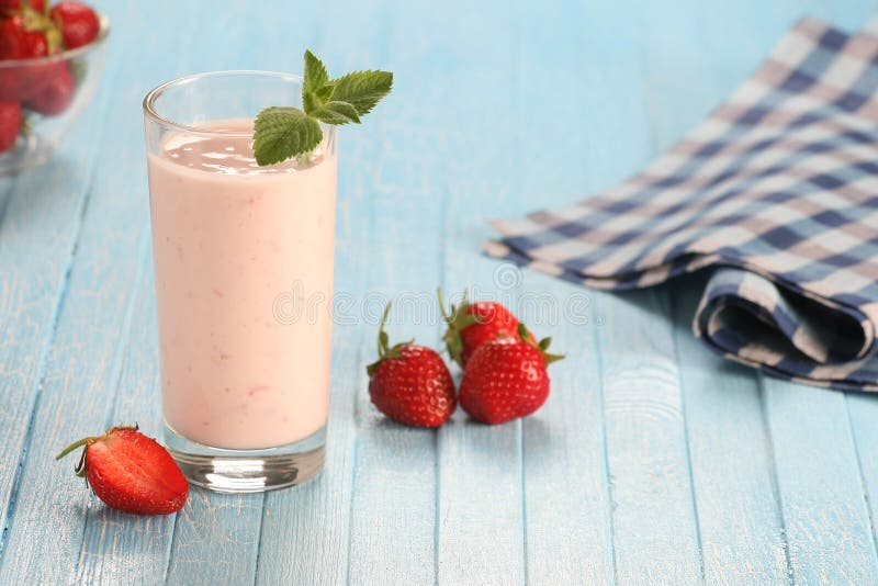 Strawberry with yogurt in a glass on a wooden background