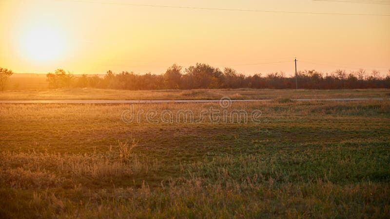 Straße auf dem Gebiet an der Glättung des Sonnenuntergangs stockfoto Straße auf dem Gebiet an der Glättung des Sonnenuntergangs stockfoto