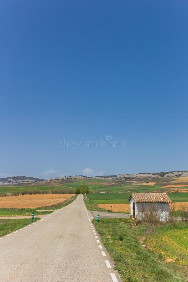 Straße und wenig weißes Haus in der Landschaft von Kastilien y Leon lizenzfreie stockfotos Straße und wenig weißes Haus in der Landschaft von Kastilien y Leon lizenzfreie stockfotos