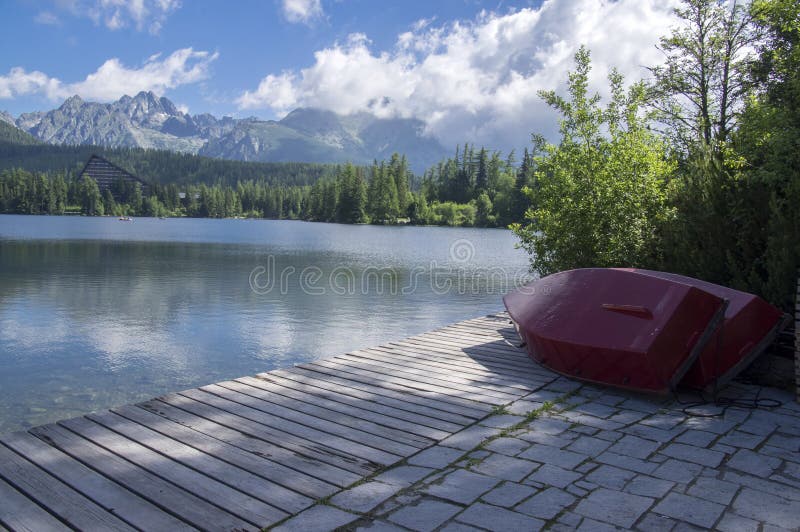 Strbske pleso, High Tatras mountains, Slovakia, early summer morning, lake reflections, red boats