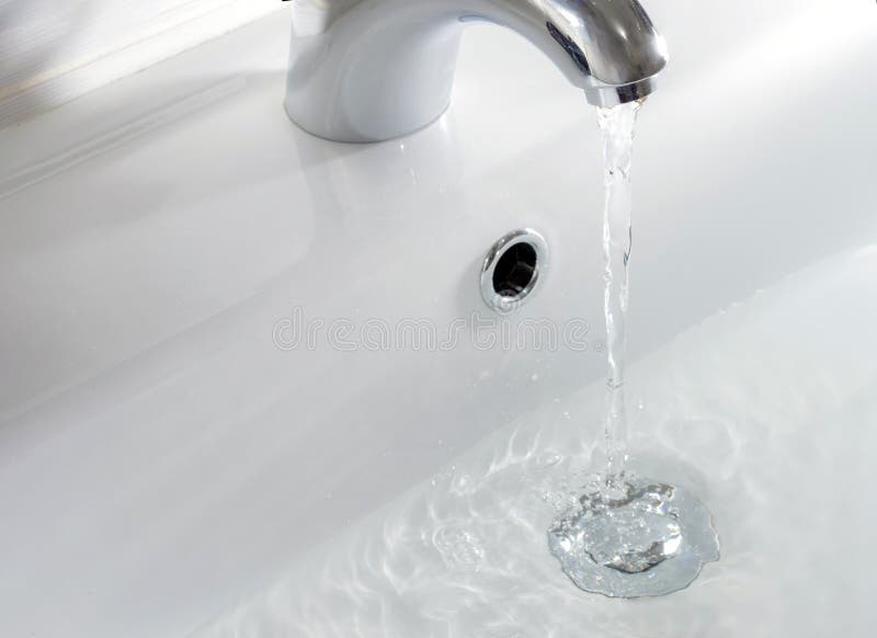 A Stream of Clean Water Pours from the Tap into the Sink Stock Image