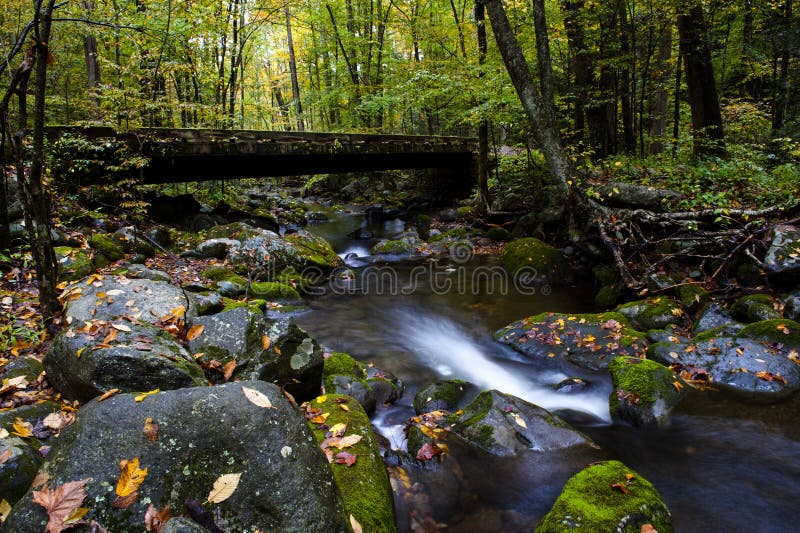 Stream in Fall at Smoky Mountain National Park. A stream in Smoky Mountain National Park in fall with water flowing under a bridge stock image Stream in Fall at Smoky Mountain National Park. A stream in Smoky Mountain National Park in fall with water flowing under a bridge stock image