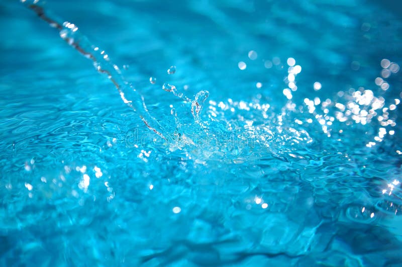 A Stream of Water Pours into the Blue Pool, Splashing Stock Photo