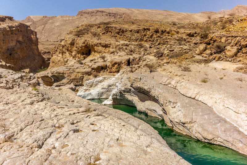 A stream of water in the rocky desert of Oman flowing in a canyon to the oasis of Wadi Bani Khalid - 3