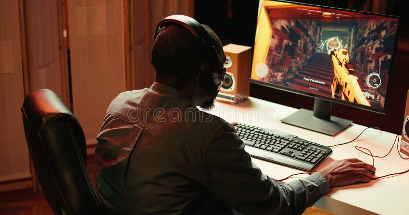 Streamer playing on PC, using headphones to talk with audience stock photo