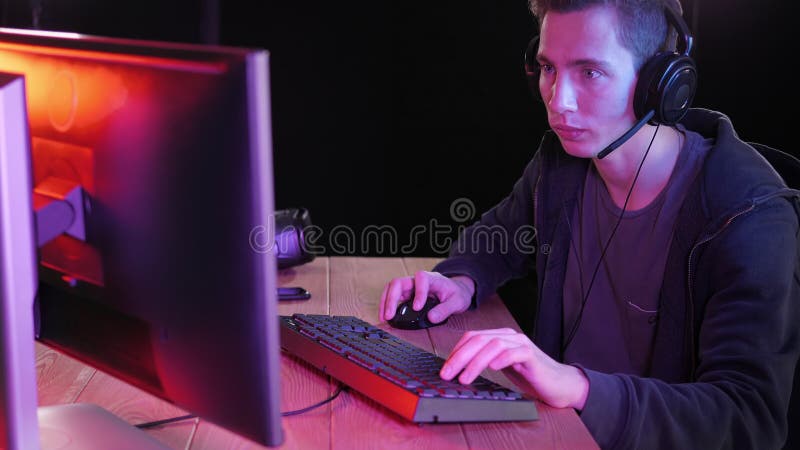 Streamer profesional jugando videojuego en línea en la noche. almacen de metraje de vídeo