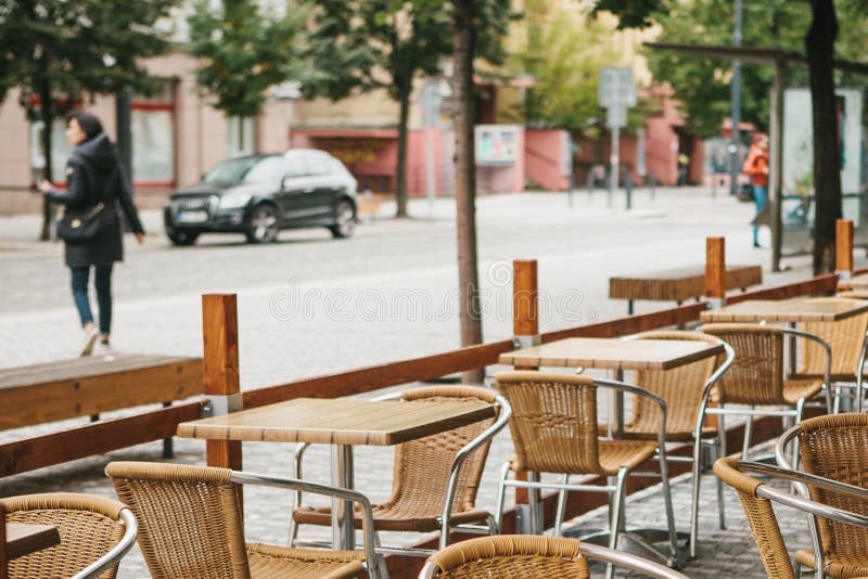 A street cafe in Prague in the Czech Republic. In the foreground there are empty wooden tables and wicker chairs. City royalty free stock image A street cafe in Prague in the Czech Republic. In the foreground there are empty wooden tables and wicker chairs. City royalty free stock image