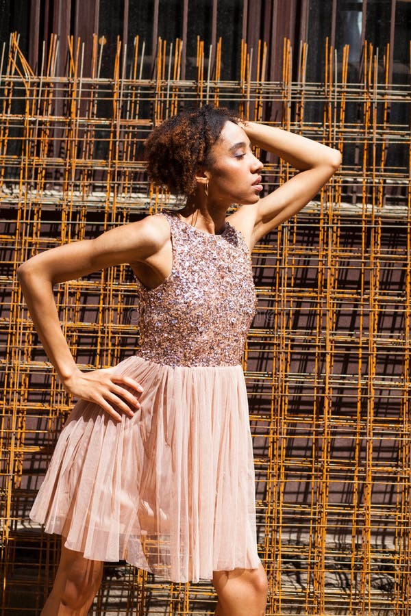 Street fashion. Portrait of an African young woman in pink dress