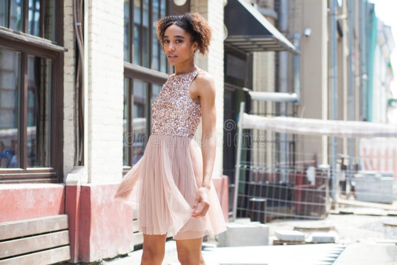 Street fashion. Portrait of an African young woman in pink dress