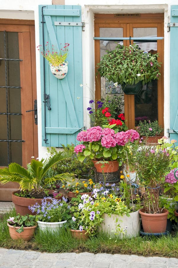 Piccola strada giardino davanti a un ingresso di casa con le piante in vaso, in Francia.