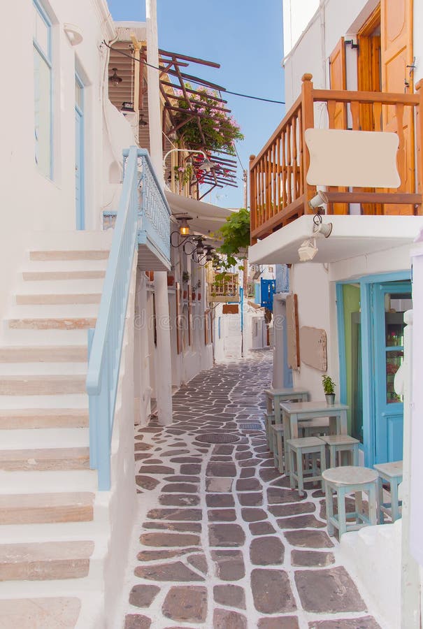 Street of Greek island with stairs, flowers and street cafe.