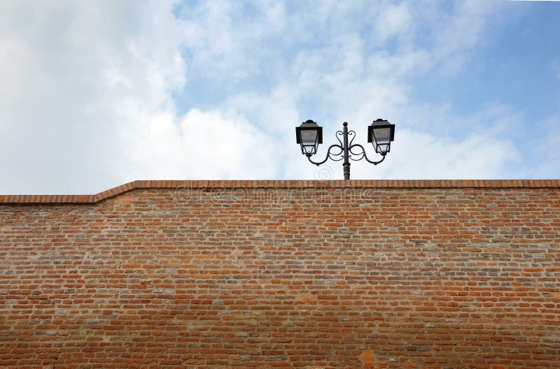 Street lamp on the top of a brick wall