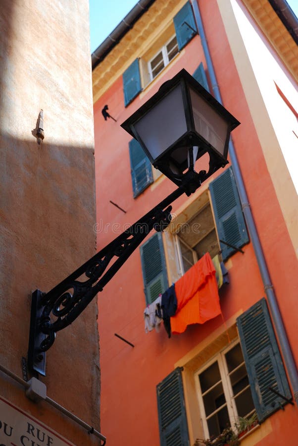 Street lamp and wall with open shutters, Nice