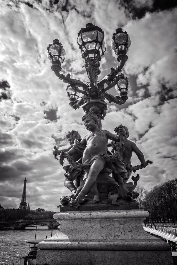 Street lantern from year 1900 on bridge Alexandre III, the river Seine and the Eiffel tower, Paris France, black and white photog