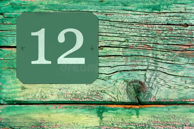 Street Number 12 on the Surface of an Old Wooden Green Door