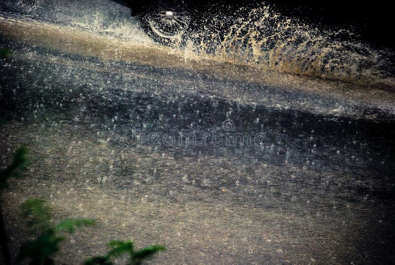 Abstract design of rain falling on car driving through puddle on road.