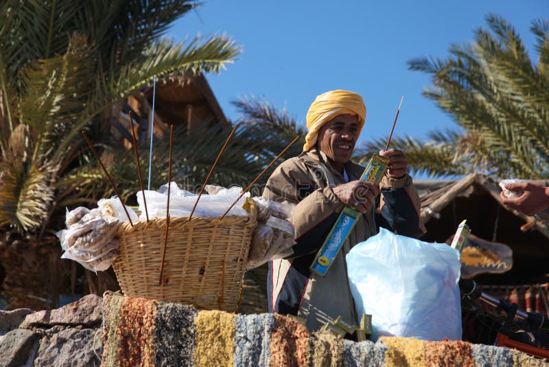 Street vendor. DAHAB - JANUARY 23. Bedouin street vendor selling food on walkway in Dahab, Egypt. Incense sticks drive the flies away stock images Street vendor. DAHAB - JANUARY 23. Bedouin street vendor selling food on walkway in Dahab, Egypt. Incense sticks drive the flies away stock images