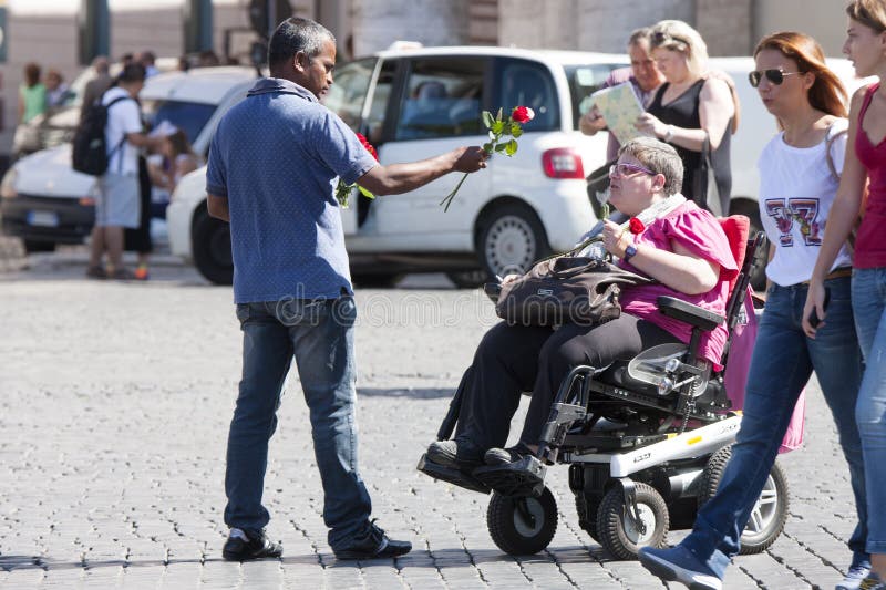 Street vendor of roses tries to sell a disabled lady