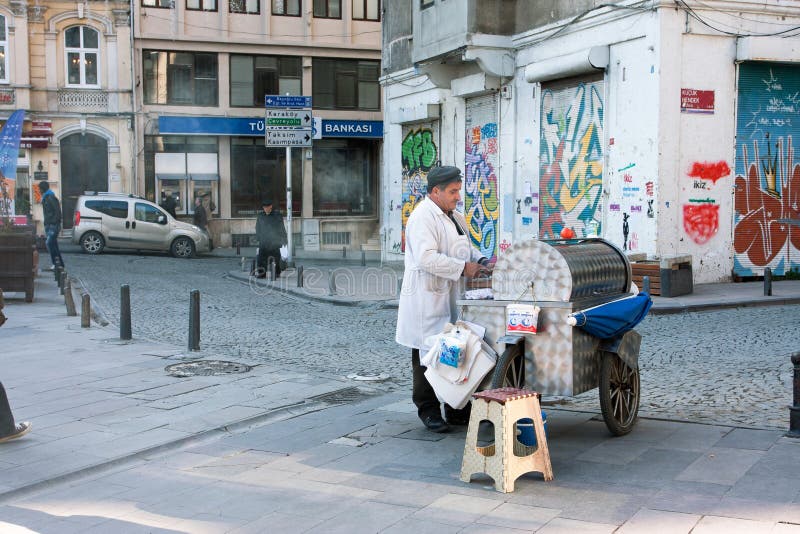 Street vendor with turkish street cart at evening of Beyoglu area in Istanbul, Turkey. The main thoroughfare of Beyoglu is 1 mile length ?stiklâl Caddesi.