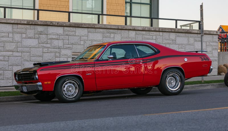 Street view of the vintage Plymouth Duster classic car parked on the sideway of the street. April 18,2021-Guildford, BC, Canada. Travel photo, street view, concept photo retro cars