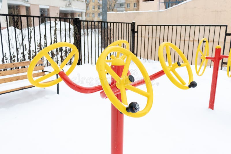 Street workout equipment in winter, outdoor sport fitness and bodybuilding. Playground, field.