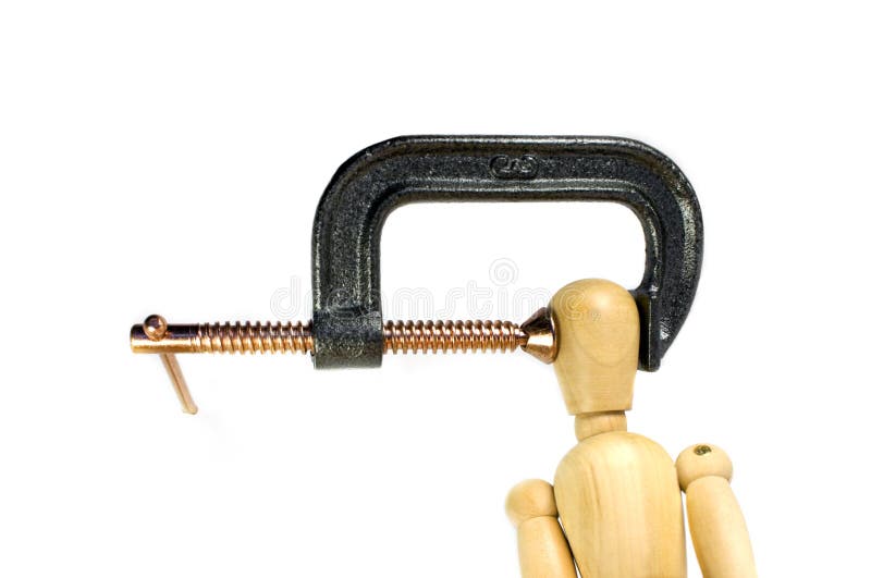 A clamp squeezing tightly on the head of a wooden man. A great concept shot for headaches or stress. A clamp squeezing tightly on the head of a wooden man. A great concept shot for headaches or stress.