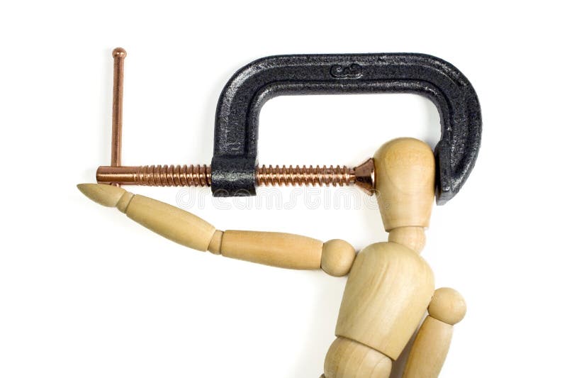 A clamp squeezing tightly on the head of a wooden man. A great concept shot for headaches or stress. A clamp squeezing tightly on the head of a wooden man. A great concept shot for headaches or stress.