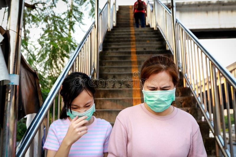 Stressed asian child girl wearing hygienic mask while walking outdoor,allergy to dust,pollution,dirty air,PM 2.5,health care,virus