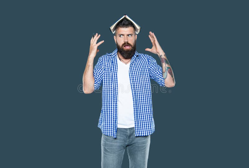 Stressed bearded man with book on head on grey background stock photos