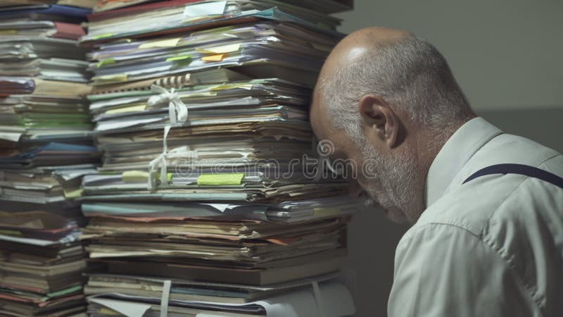 Stressed business executive overloaded with paperwork