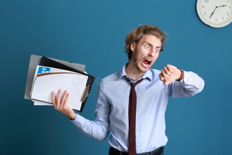 Stressed businessman trying to meet deadline on color background