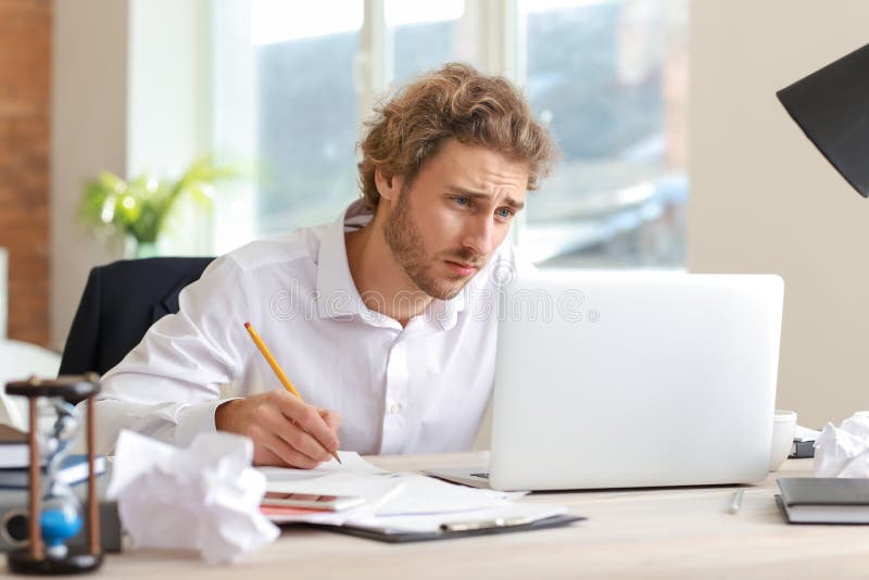 Stressed businessman trying to meet deadline in office