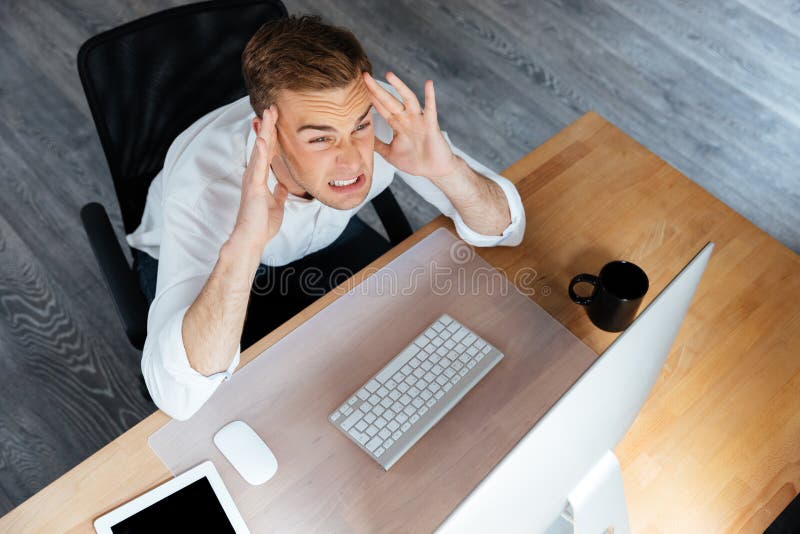 Stressed Businessman Working with Computer and Having Headache in