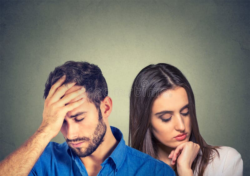 Stressed sad young couple man and woman looking down stock photos Stressed sad young couple man and woman looking down stock photos