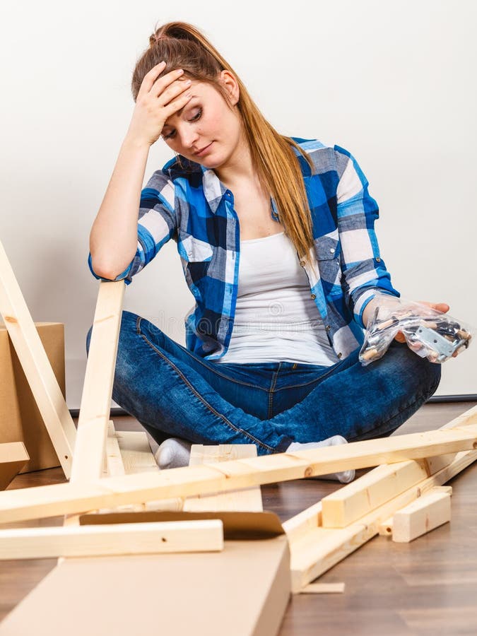 Stressed woman assembling wooden furniture. DIY.