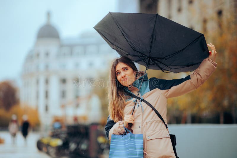 Stressed Woman Walking in the Rain with Broken Umbrella Stock Image