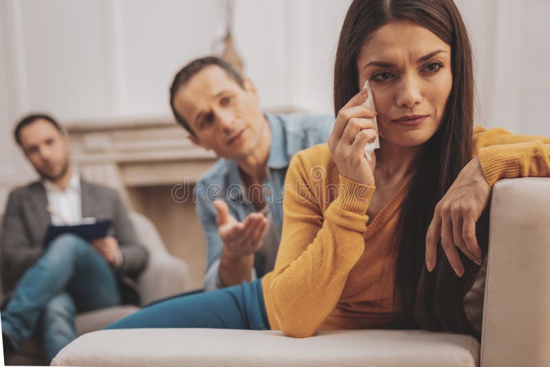 Stressed woman wiping her tears during psycho session