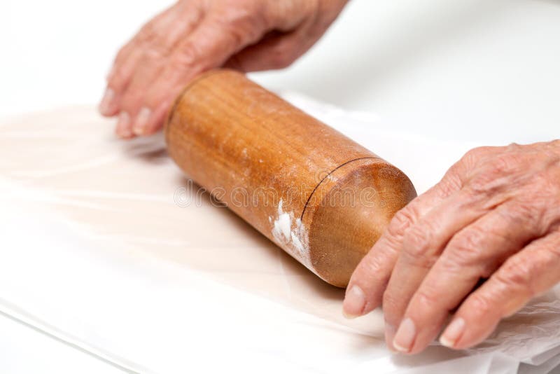 Stretching Dough Using a Plastic Bag and a Rolling Pin Stock Photo