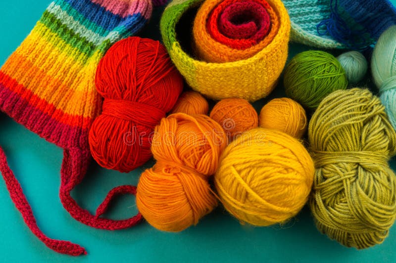 Stricken eines Regenbogenschal und -hut Blauhintergrundes lizenzfreie stockfotos Stricken eines Regenbogenschal und -hut Blauhintergrundes lizenzfreie stockfotos