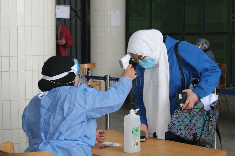 Strict precautionary measures before a building entry, temperature screening, face masks, hand gels royalty free stock photography
