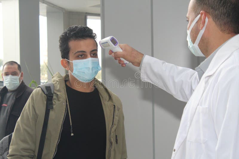 Strict precautionary measures before a building entry, temperature screening, face masks, hand gels royalty free stock photos