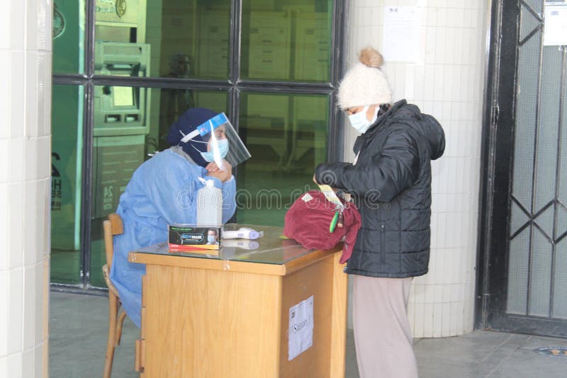 Strict precautionary measures before a building entry, temperature screening, face masks, hand gels stock images