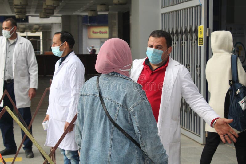Strict precautionary measures before a building entry, temperature screening, face masks, hand gels royalty free stock image