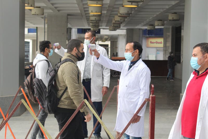 Strict precautionary measures before a building entry, temperature screening, face masks, hand gels stock images