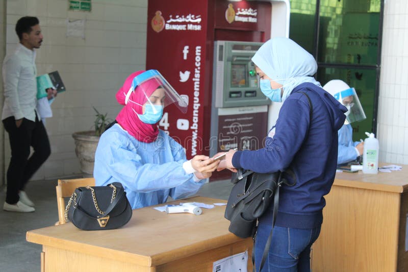 Strict precautionary measures before a building entry, temperature screening, face masks, hand gels stock photography